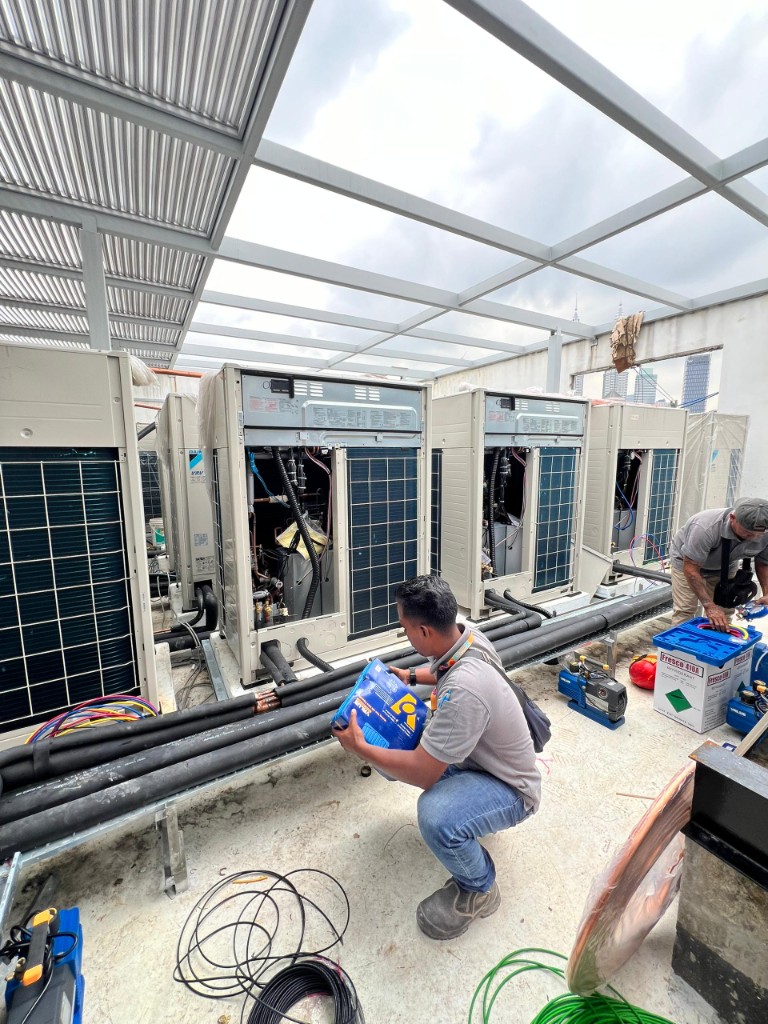TKH Industries HVAC technicians servicing rooftop condenser units