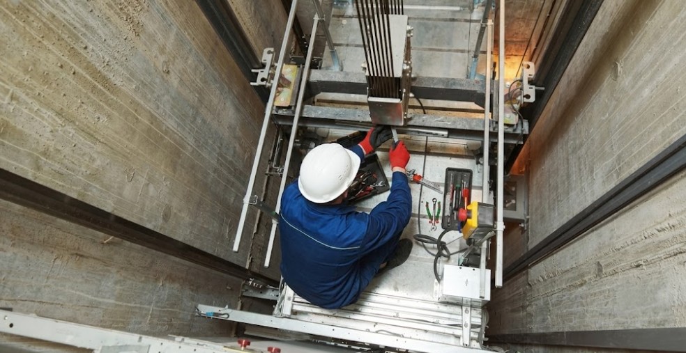 Lift installers testing hoist cables in a shaft