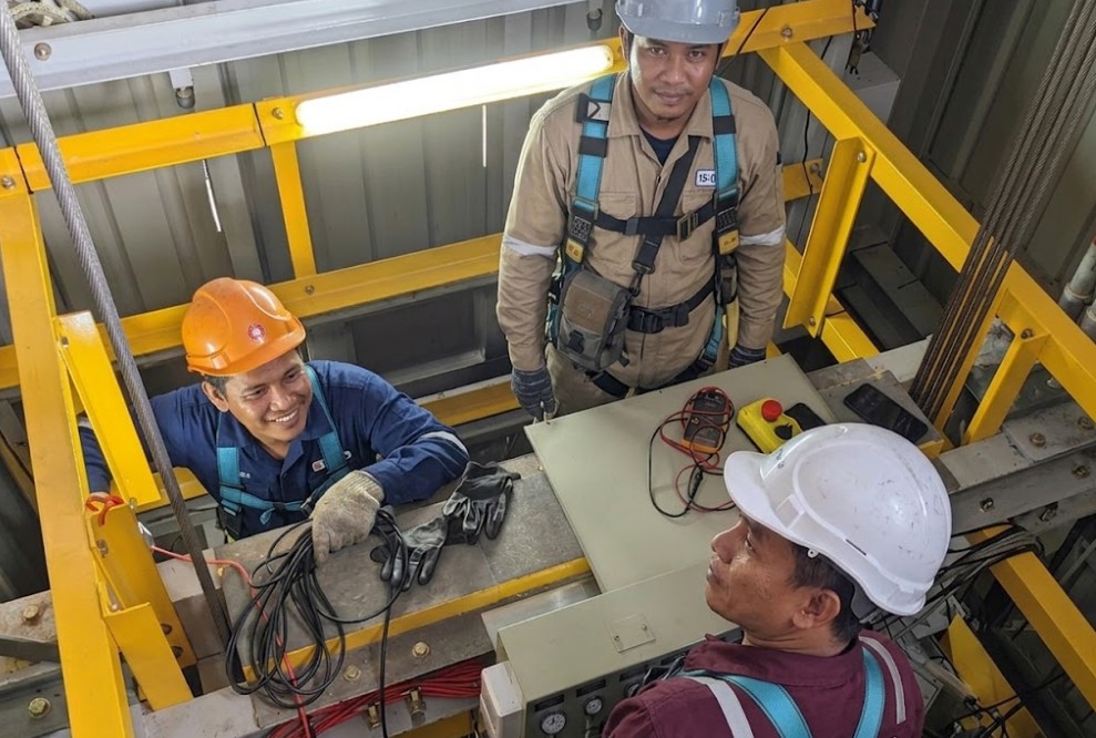 Elevator technicians working inside a lift shaft on a commercial project